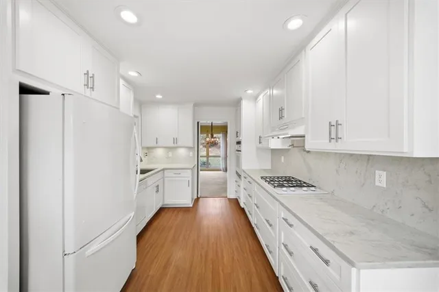 a kitchen with white cabinets and appliances