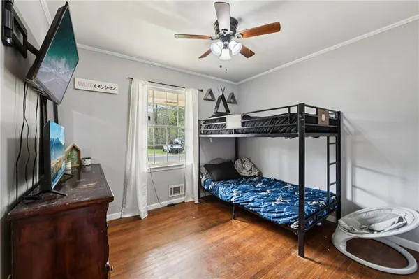 a bedroom with a bed and a flat tv screen on the dresser