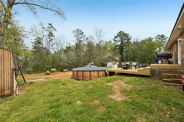 a view of a swimming pool with a patio and a yard