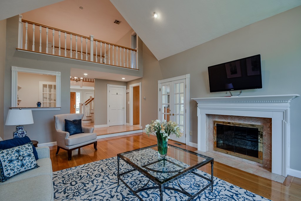 929 Salem End Road Framingham, MA 01702 - Photo 8 of 29 a living room with furniture a flat screen tv and a fireplace