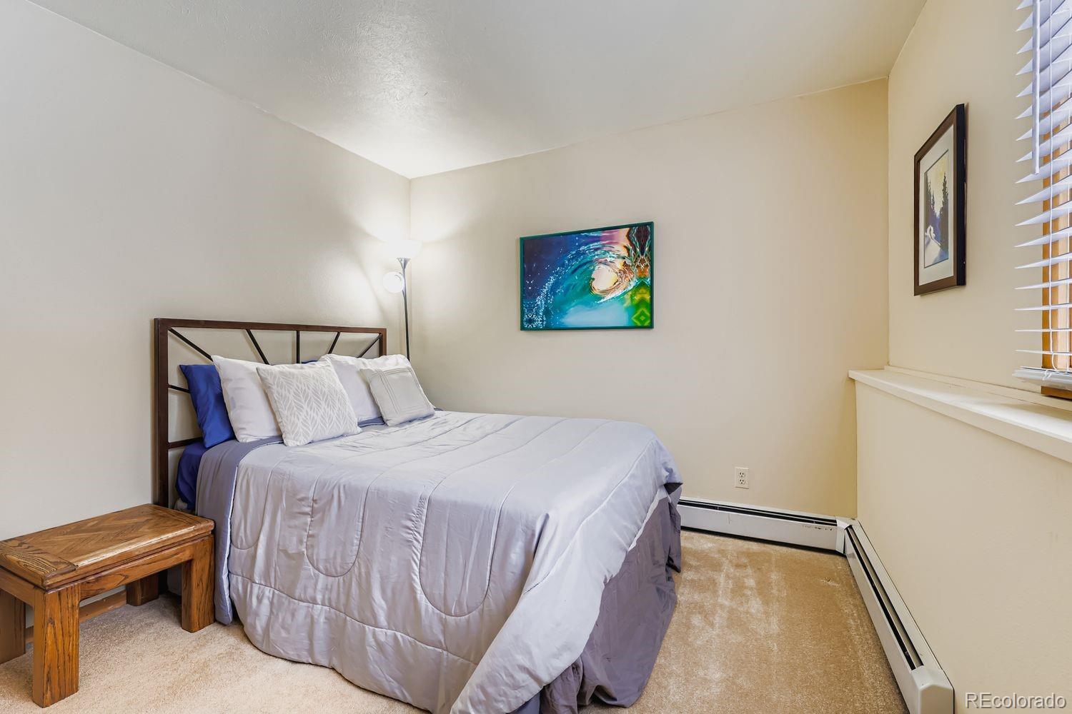91300 Ryan Gulch Road, Unit 91305 Silverthorne, CO 80498 - Photo 19 of 40 a bedroom with a bed and a wall painting