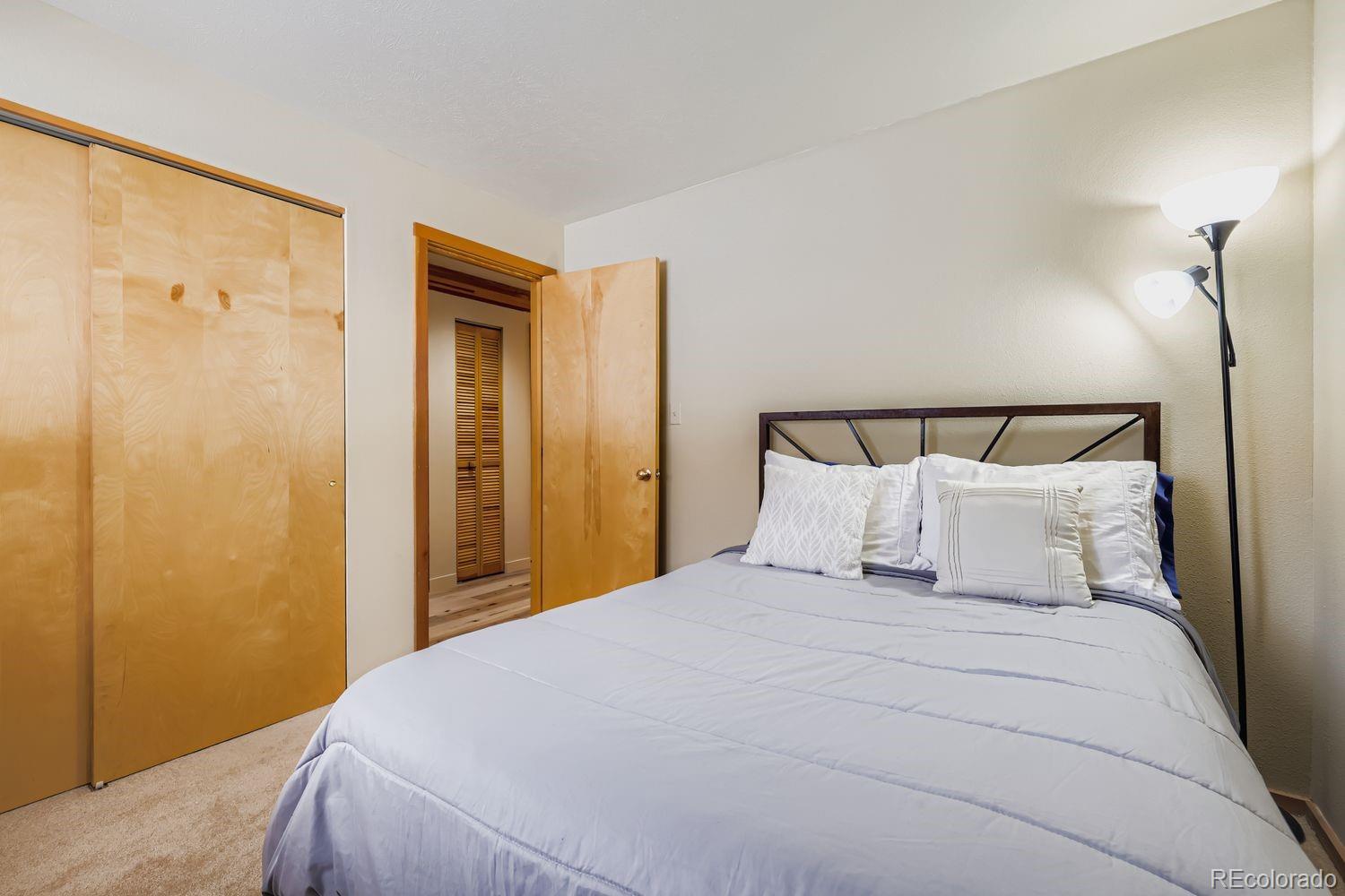 91300 Ryan Gulch Road, Unit 91305 Silverthorne, CO 80498 - Photo 20 of 40 a bedroom with a bed and a mirror