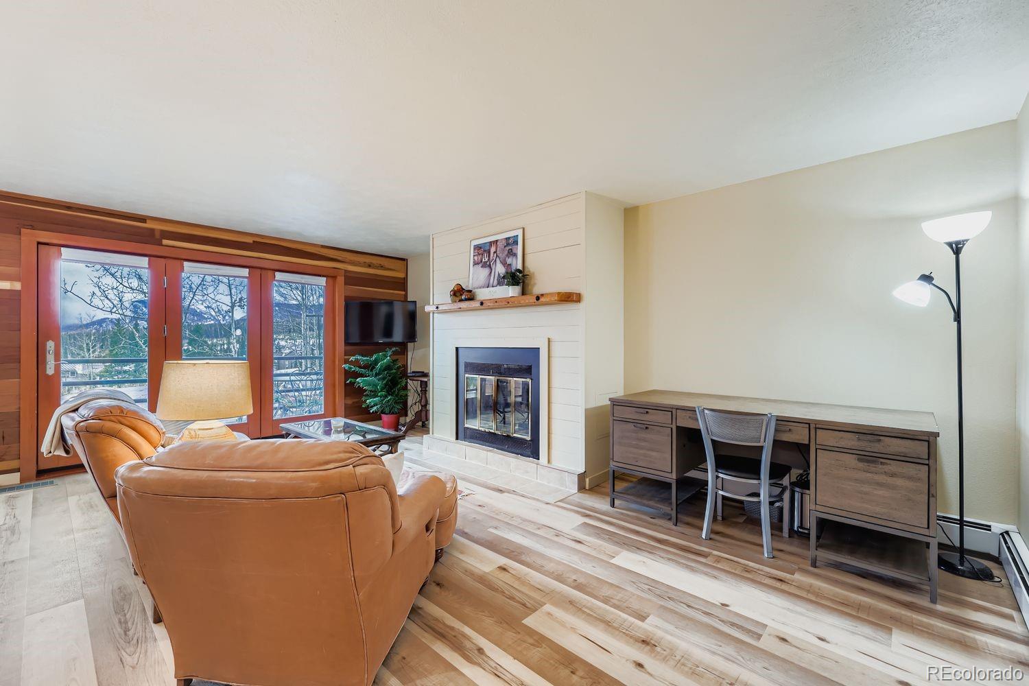 91300 Ryan Gulch Road, Unit 91305 Silverthorne, CO 80498 - Photo 10 of 40 a living room with furniture a fireplace and a floor to ceiling window