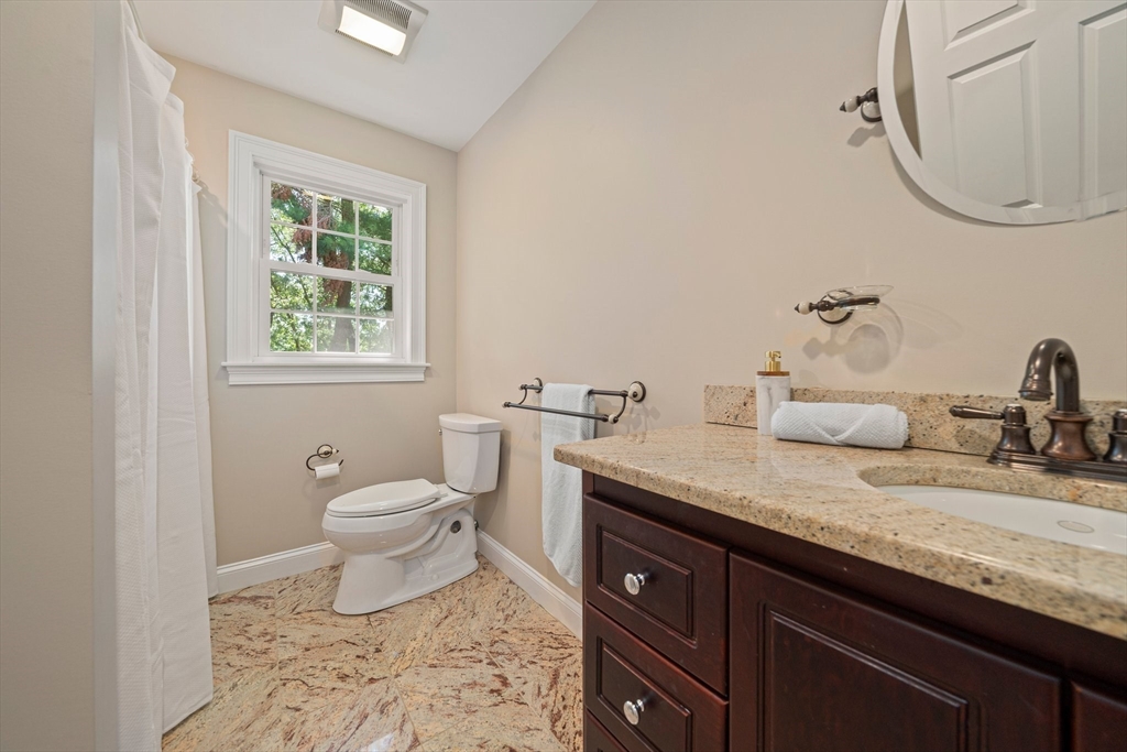 65 Grand Street Canton, MA 02021 - Photo 19 of 39 a bathroom with a granite countertop sink a toilet and a mirror