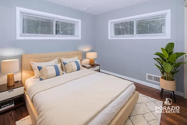 a bed sitting in a bedroom next to a window with potted plant