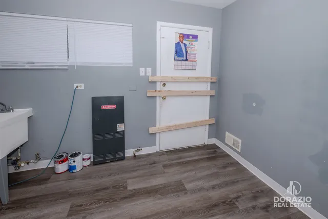 a view of an empty room with wooden floor and cabinet