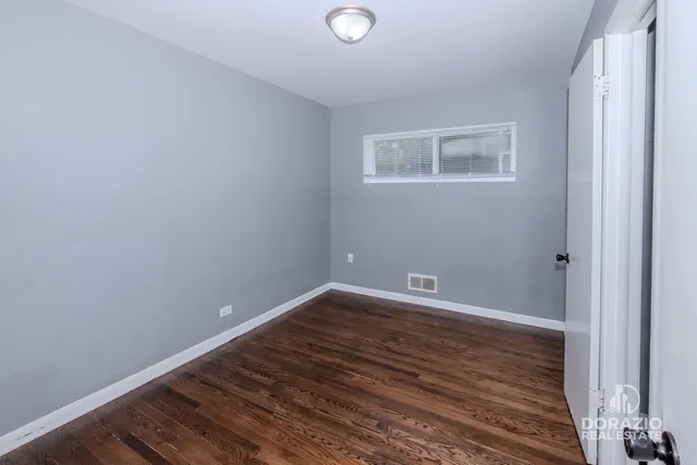 a view of a room with wooden floor and window