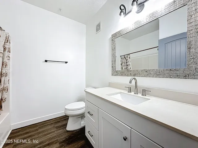 a bathroom with a sink a toilet and mirror