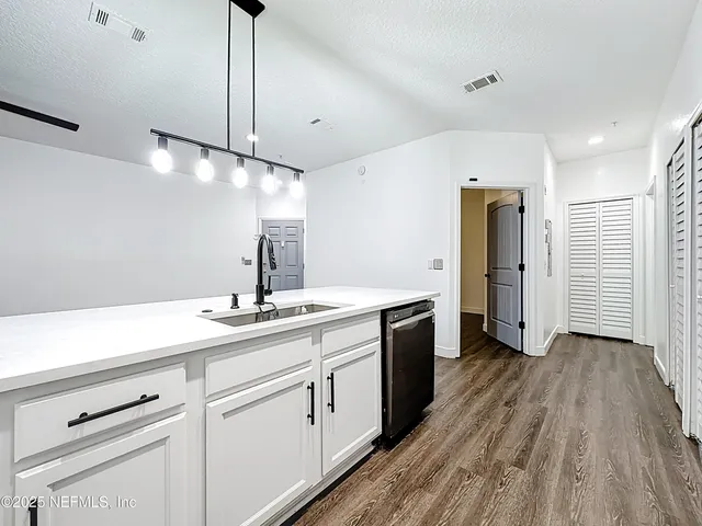 a kitchen with a sink stainless steel appliances and cabinets