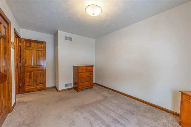 a bedroom with a bed and a refrigerator