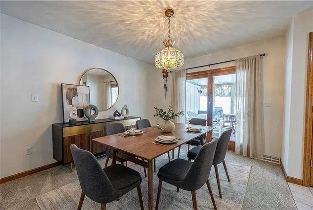 a view of a dining room with furniture a chandelier and wooden floor