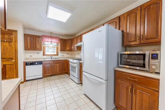 a kitchen with granite countertop a refrigerator stove top oven and sink