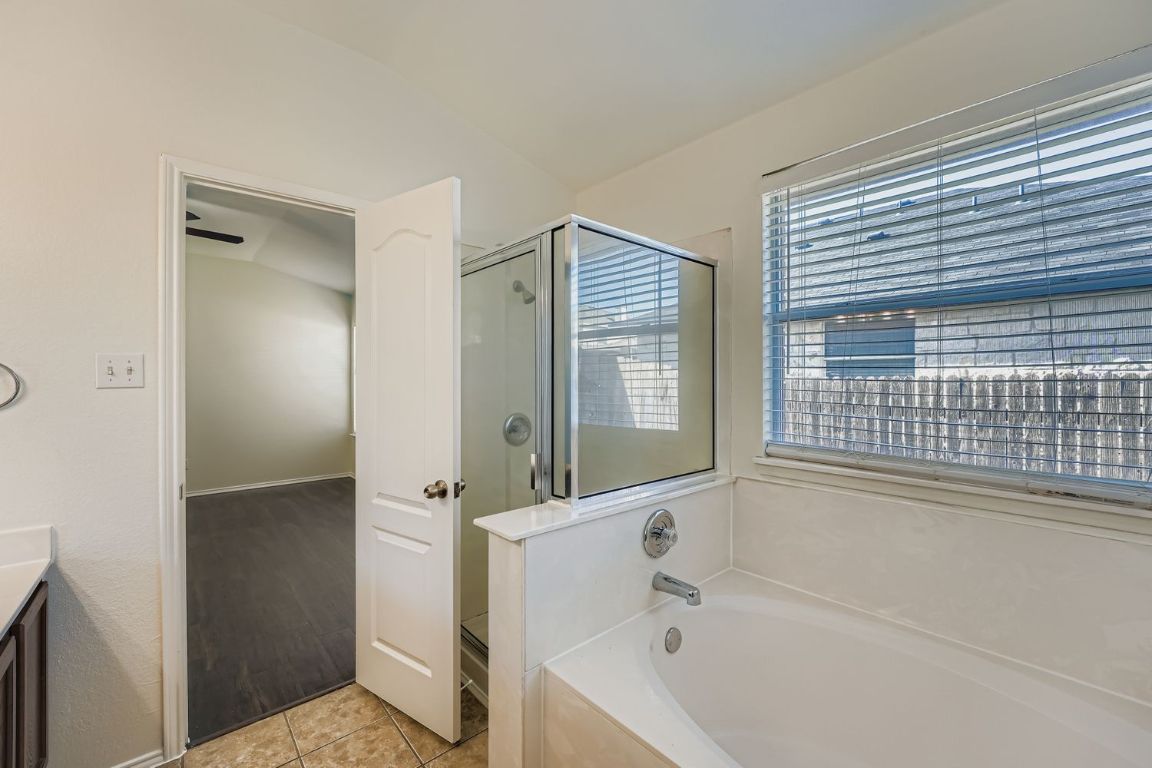 12612 Waynespur Lane Elgin, TX 78621 - Photo 13 of 22 a bathroom with a bathtub and a shower