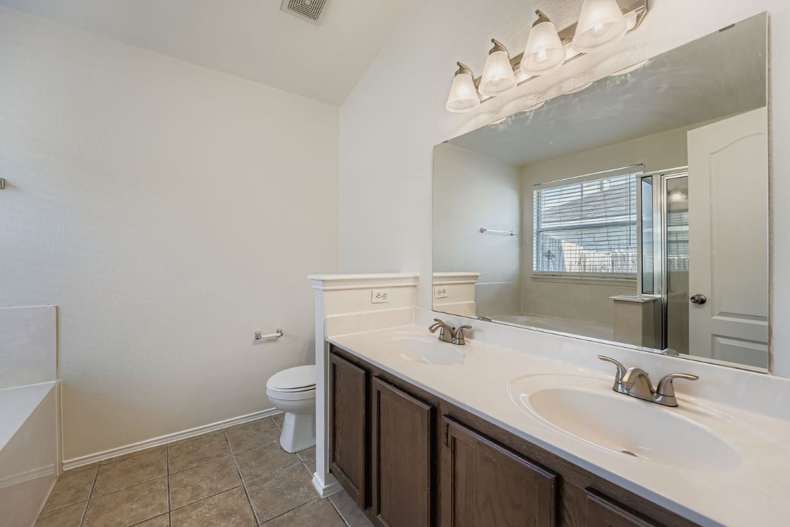 12612 Waynespur Lane Elgin, TX 78621 - Photo 15 of 22 a bathroom with a sink a toilet and a mirror