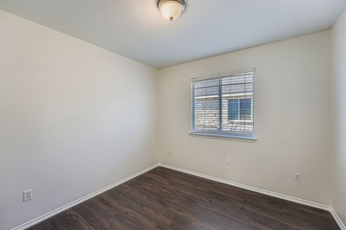 12612 Waynespur Lane Elgin, TX 78621 - Photo 19 of 22 an empty room with wooden floor and windows