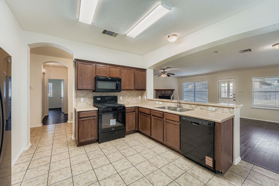 12612 Waynespur Lane Elgin, TX 78621 - Photo 9 of 22 a large kitchen with stainless steel appliances granite countertop a stove and a sink
