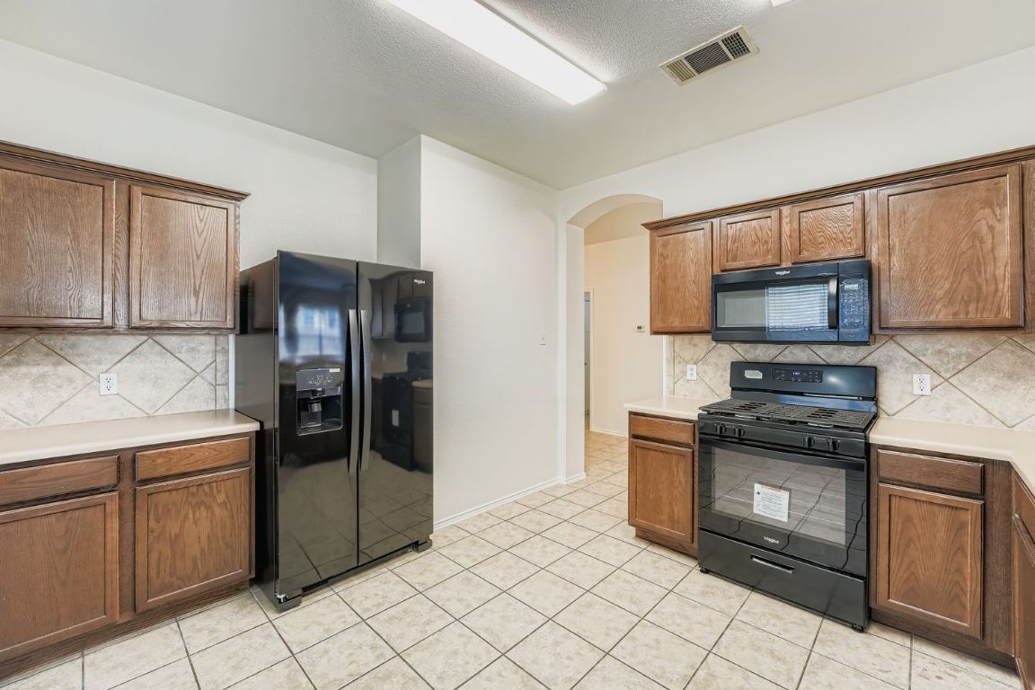 12612 Waynespur Lane Elgin, TX 78621 - Photo 10 of 22 a kitchen with granite countertop a cabinets and steel stainless steel appliances