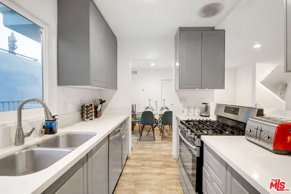 a kitchen with sink a stove and cabinets