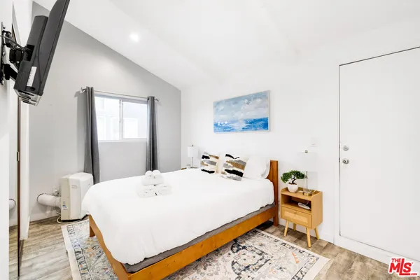a bedroom with a bed and a flat screen tv
