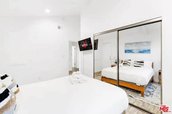 a spacious bedroom with a bed and a flat screen tv