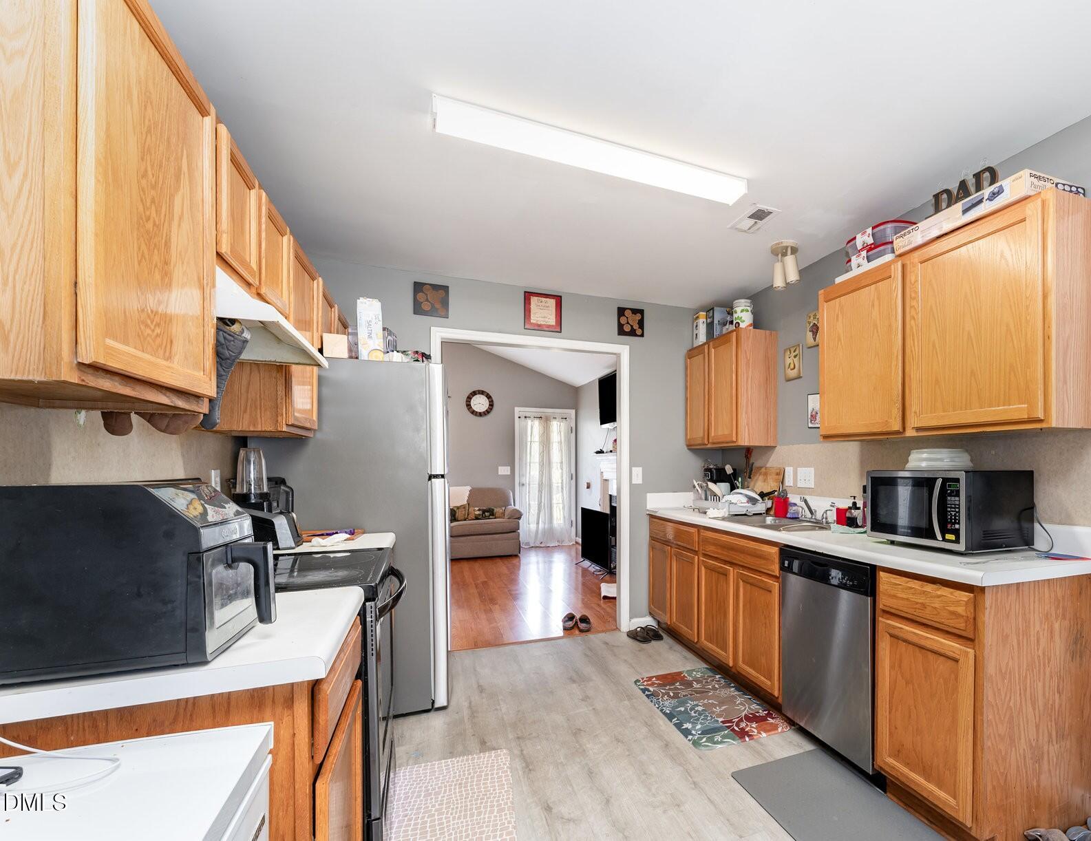 4004 Grandover Drive Raleigh, NC 27610 - Photo 2 of 7 a kitchen with stainless steel appliances granite countertop a sink stove and refrigerator