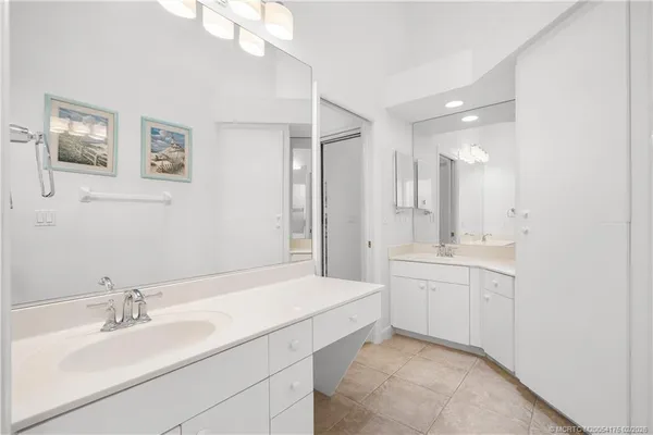 a bathroom with a sink double vanity granite tub shower and a mirror