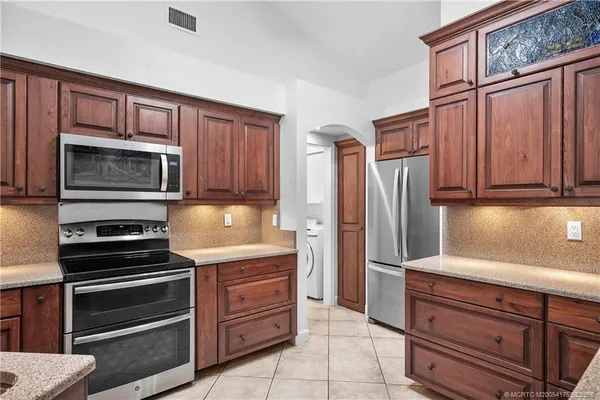 a kitchen with granite countertop wooden cabinets and stainless steel appliances