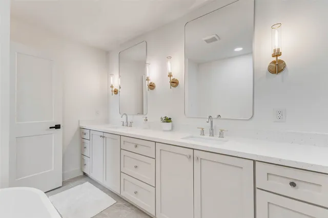 a bathroom with a double vanity sink mirror and shower