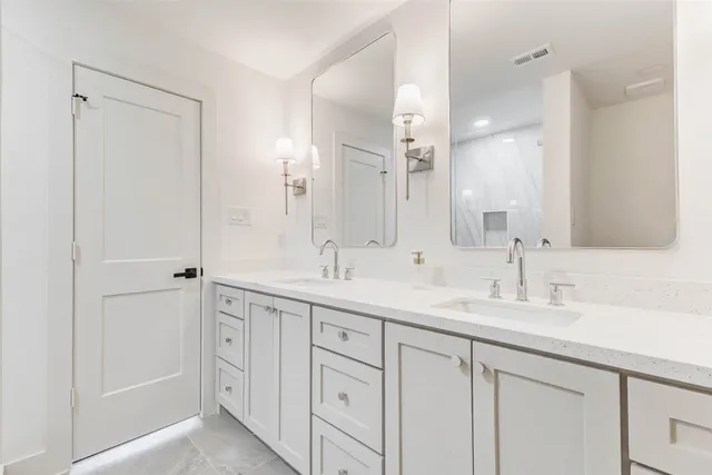 a bathroom with a double vanity sink and a mirror