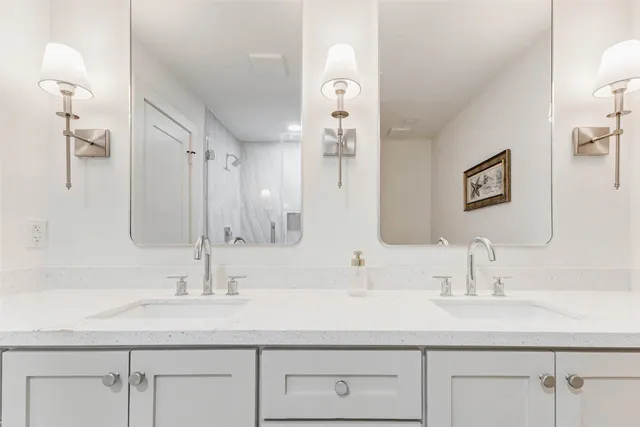 a bathroom with double sink and a mirror
