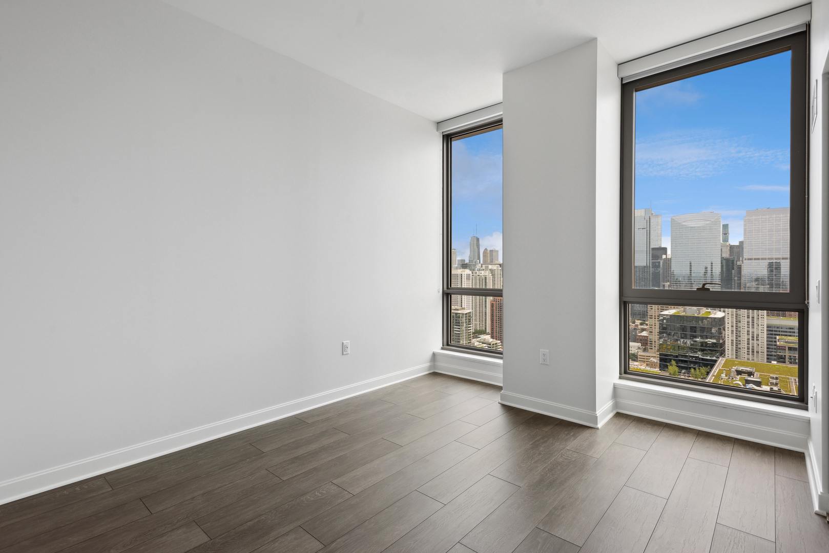 164 North Peoria Street, Unit 4004 Chicago, IL 60607 - Photo 27 of 32 an empty room with wooden floor and windows