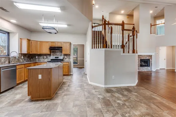 a kitchen with stainless steel appliances granite countertop a refrigerator a sink a stove top oven and a refrigerator