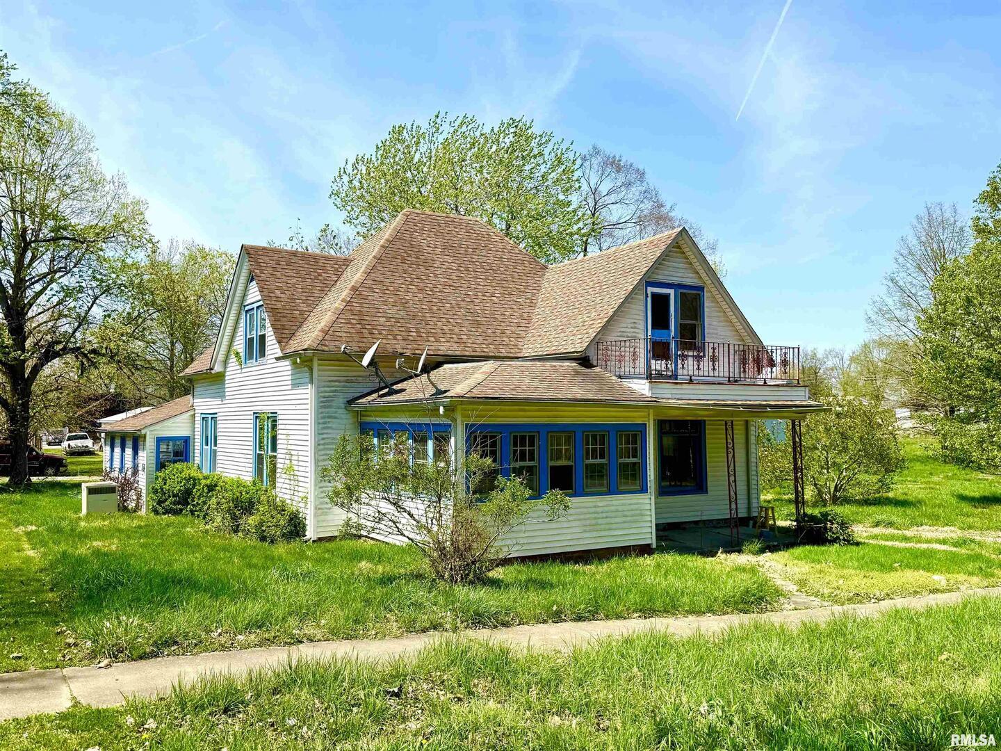 a view of a house with a yard potted plants and large tree