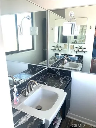 a bed sitting in a bedroom next to a window with a book shelf