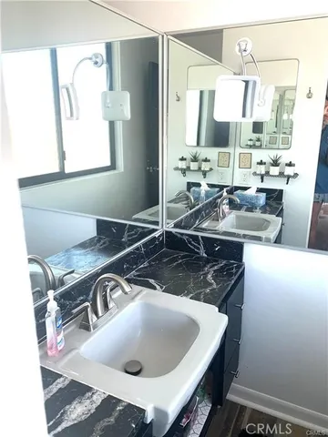 a bed sitting in a bedroom next to a window with a book shelf