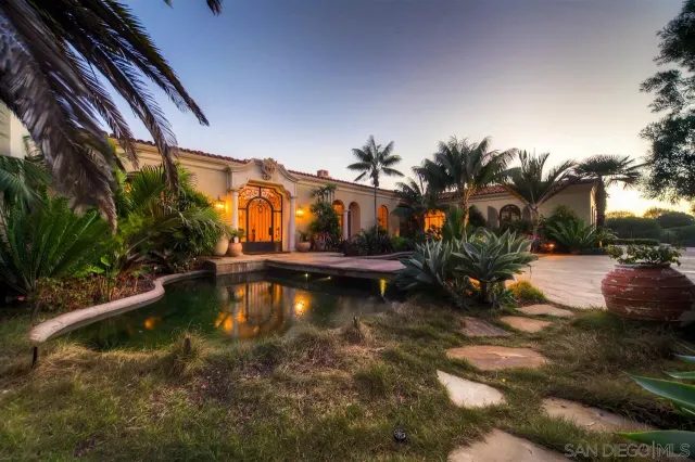 a view of swimming pool with outdoor seating and trees in the background
