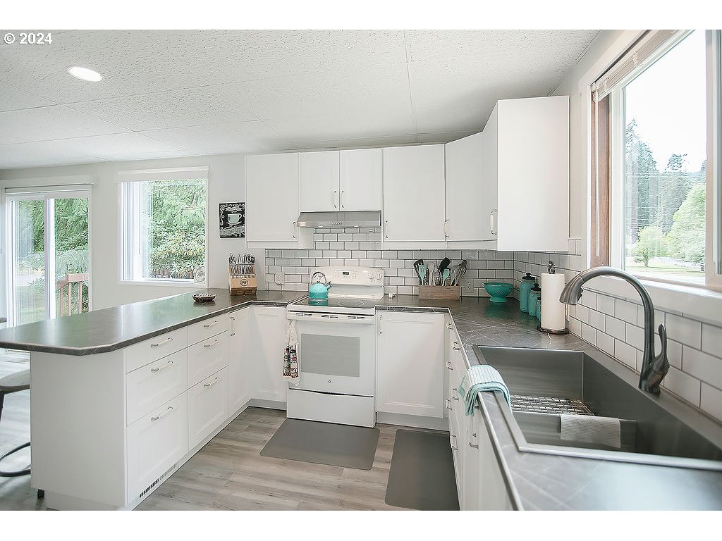 115 Stewart Creek Road Longview, WA 98632 - Photo 11 of 31 a kitchen with granite countertop a window a sink and white appliances