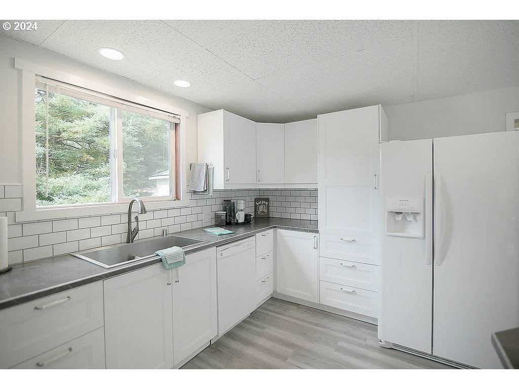 115 Stewart Creek Road Longview, WA 98632 - Photo 12 of 31 a kitchen with white cabinets and window