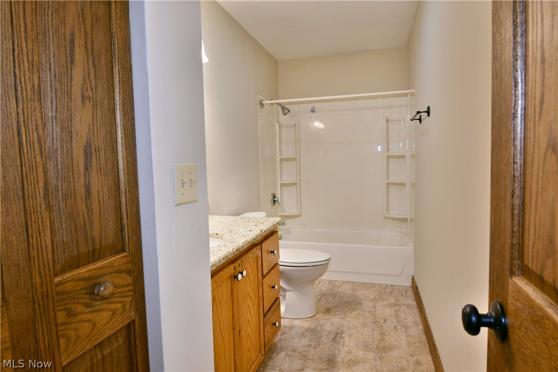 754 Warner Road Hubbard, OH 44425 - Photo 21 of 46 Bathroom featuring a white bathtub and shower combination with integrated shelving, light-colored walls, and wood-finish flooring