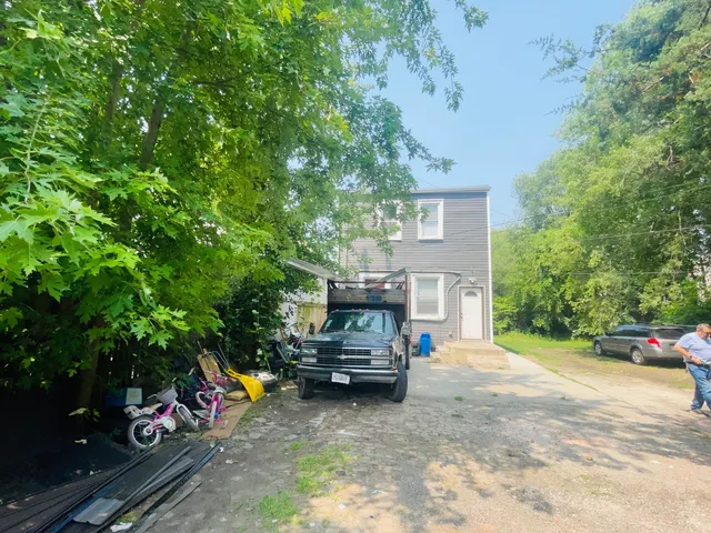 a view of a street with a bench and some trees