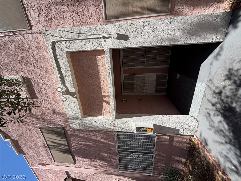 2236 East Desert Inn Road Las Vegas, NV 89169 - Photo 2 of 34 A secured front entrance, carved into the textured stucco exterior, awaits behind decorative metal grates.