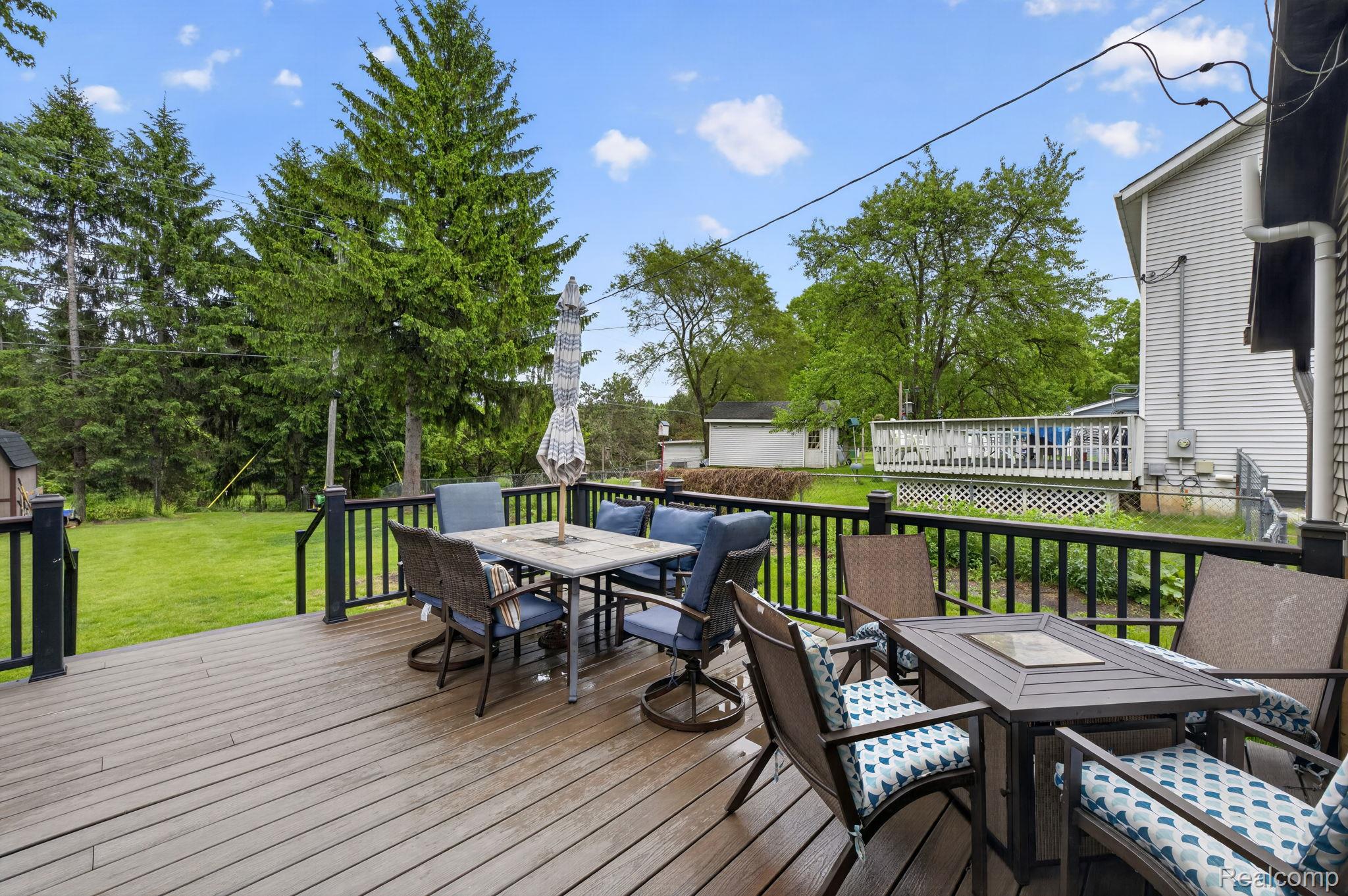 1280 Petts Road Fenton, MI 48430 - Photo 47 of 62 Wooden terrace featuring outdoor dining area and a yard