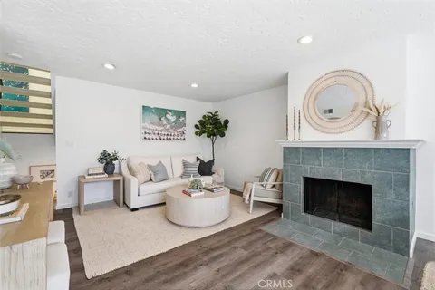 a living room with furniture a fireplace and a large window