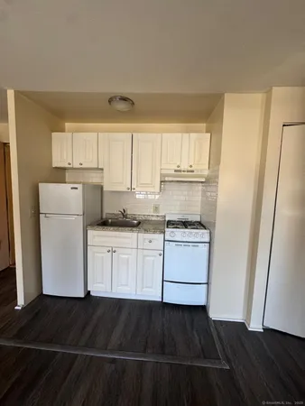a kitchen with a refrigerator and white cabinets