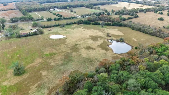 an aerial view of a house with a yard and lake view
