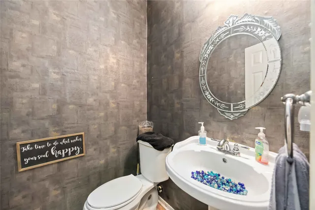 a bathroom with a toilet a sink and a mirror