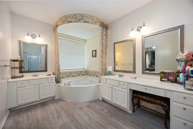 a bathroom with a tub a double vanity sink and mirror