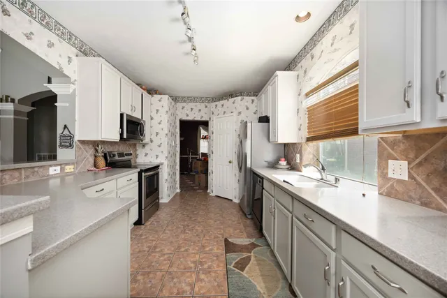 a kitchen with granite countertop a sink appliances cabinets and furniture