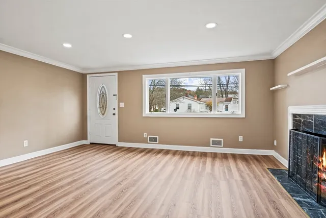 a view of an empty room with a fireplace and a window