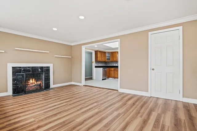 a view of empty room with wooden floor and fireplace